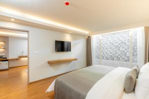 a bedroom with a bed and a tv on a wall at Shambhala Hotel Pattaya in Pattaya +43 photos