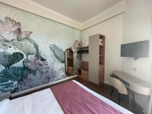 a bedroom with a desk and a painting on the wall at Lolli Palace Hotel in Sanremo