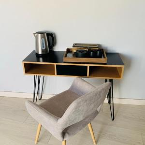 un escritorio con una silla junto a una pared blanca en Maison de village au cœur de la Drôme Médiévale - Les Remparts - Drôme provençale, en Châteauneuf-du-Rhône