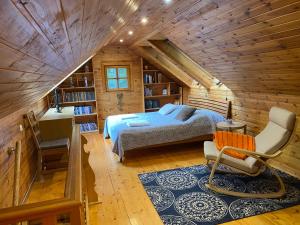 ein Schlafzimmer mit einem Bett in einer Holzhütte in der Unterkunft Medaus pirtelė in Trakai