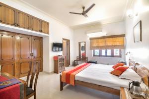 a bedroom with a large bed and a table at Girisadan Boutique Hotel in Jaipur