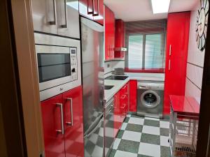 cocina con armarios rojos y lavadora en Piso turístico en Granada. Zona Palacio Deportes en Granada