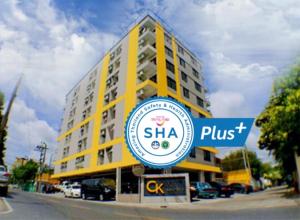 CK2 Hotel SHA EXTRA PLUS في بانكوك: مبنى اصفر امامه لافته
