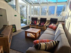 a living room with a couch and chairs and windows at Ruime, gezellige vakantiewoning nabij Winterberg voor 2 tot 6 rustige natuurliefhebbers in Schmallenberg