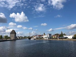 a view of a river with a town and a barn at Ferienwohnung Bress in Ueckermünde