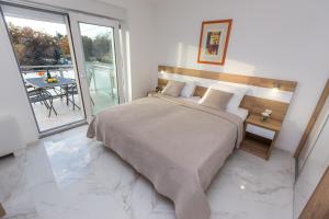 1 dormitorio con 1 cama grande y 1 mesa en Apartmani Villa Paulo en Starigrad-Paklenica