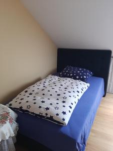 a blue bed with a pillow on top of it at Der kleine Bauernhof keine Arbeiter zadnych pracownikow in Lubiatow