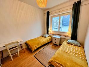 Habitación con 2 camas, escritorio y ventana. en Appartement de Charme de 75m², Lumineux et Calme, en Nantes