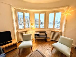 - un salon avec deux chaises et une télévision à écran plat dans l'établissement Appartement de Charme de 75m², Lumineux et Calme, à Nantes