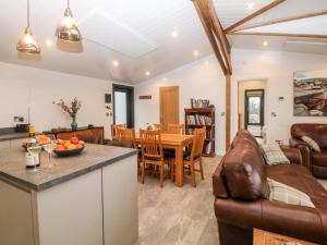 eine Küche und ein Wohnzimmer mit einem Sofa und einem Tisch in der Unterkunft Stables Lodge in Chesterfield