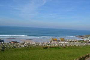 a beach with a bunch of chairs and the ocean at Tregony Guest House in St Ives