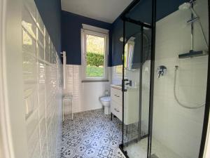 La salle de bains est pourvue d'une douche, d'un lavabo et de toilettes. dans l'établissement Happy Guest Apartments - Blue Apartment, à Riva di Solto