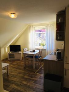 cocina y comedor con mesa y ventana en Sommerbrise 1, en Norddeich