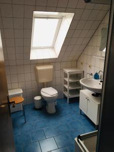 baño con aseo y lavabo y ventana en Sommerbrise 1, en Norddeich