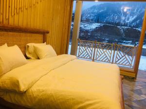 Woodridge Cottages Kalam في Kalām: غرفة نوم مع سرير مطل على الجبل