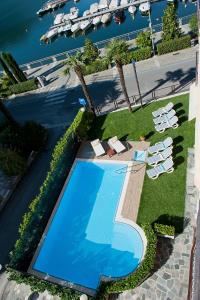 an overhead view of a swimming pool with chaise lounge chairs and a resort at Hotel Europa in Porlezza