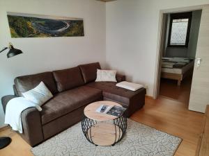 a living room with a brown couch and a table at Ferienwohnung Roter Riesling in Zell an der Mosel