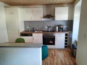 a kitchen with white cabinets and a counter top at Ferienwohnung Roter Riesling in Zell an der Mosel