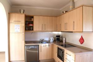 uma cozinha com armários de madeira e um forno com placa de fogão em Casa La Aurora em Arenas