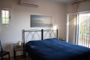 um quarto com uma cama azul e uma janela em Casa La Aurora em Arenas