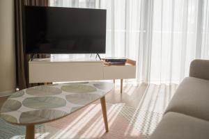a living room with a tv and a coffee table at Apartment DoMiSol in Druskininkai