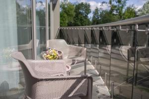 a porch with chairs and a vase of flowers on it at Apartment DoMiSol in Druskininkai +8 photos