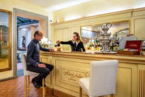 a woman sitting at a bar in front of a counter at Hotel Alba Palace in Florence
