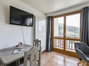 a room with a table and a television on a wall at Appartement Courchevel 1650, 2 pièces, 5 personnes - FR-1-514-65 in Courchevel