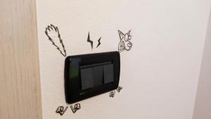 a tv hanging on a wall with someooky drawings at Casa Dolcitalia a Gardaland con piscina in Ronchi