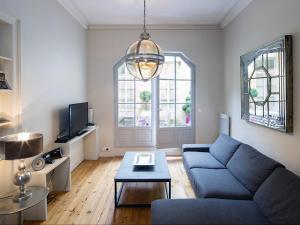 ein Wohnzimmer mit einem blauen Sofa und einem Tisch in der Unterkunft Bord'ôappart Le Cheverus in Bordeaux