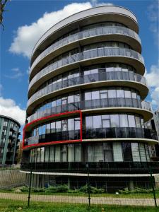 a round glass building with a red trim at Apartment DoMiSol in Druskininkai