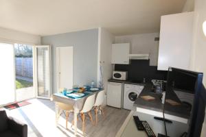 a small kitchen with a table and chairs in a room at Appartement SOULAC SUR MER À 500 m de la plage N 2 in Soulac-sur-Mer