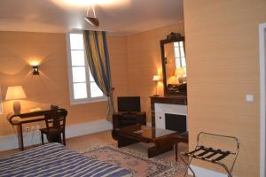 a bedroom with a bed and a desk and a mirror at Hôtel de France in Libourne