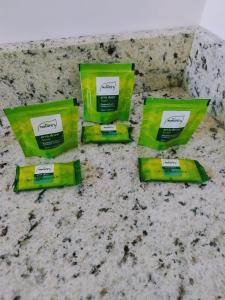 quatro pacotes de pasta de dentes verde sentados num balcão em Hotel Pousada Bueno's em Francisco Beltrão