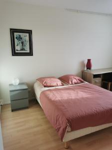 a bedroom with a bed with red sheets and a desk at MASSY VILMORIN Appartement indépendant 3 pieces in Massy