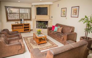 ein Wohnzimmer mit 2 Sofas und einem TV in der Unterkunft Hotel Monte Carlo in Uruguaiana