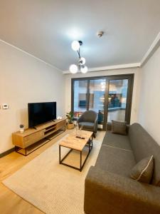 een woonkamer met een bank en een flatscreen-tv bij Central Modern Apartment by Siena Suites in Istanbul