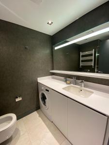 een badkamer met een wastafel en een wasmachine bij Central Modern Apartment by Siena Suites in Istanbul
