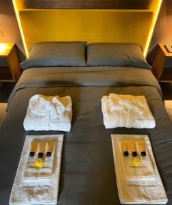 - un lit avec des serviettes et 2 tables dans l'établissement Fiorini Rooms Pescasseroli, à Pescasseroli