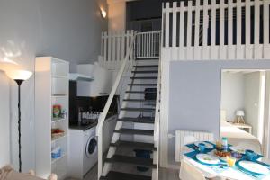 eine weiße Treppe in einem kleinen Zimmer mit einer Küche in der Unterkunft Appartement SOULAC SUR MER À 500 m de la plage N 3 in Soulac-sur-Mer