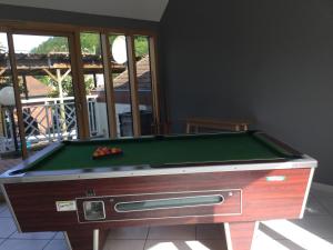 uma mesa de bilhar sentada numa sala de estar com uma piscina em Maison Bord de Mer em Dieppe