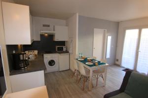 a kitchen with a table and a kitchen with a counter top at Appartement SOULAC SUR MER À 500 m de la plage N 5 in Soulac-sur-Mer +9 photos