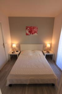 a bedroom with two lamps on two sides of a bed at Appartement SOULAC SUR MER À 500 m de la plage N 5 in Soulac-sur-Mer