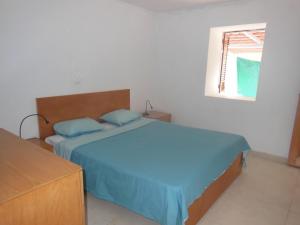 a bedroom with a bed with blue sheets and a window at Casa Pé di Polon holiday home in Picos
