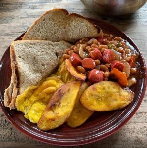a plate of breakfast food with eggs beans and toast at Jay's Guest House II in Epping Farm