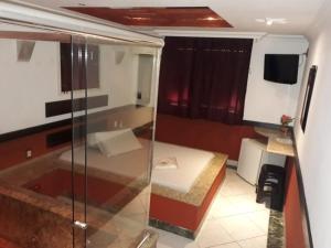 a bathroom with a shower and a bed in a room at Motel dos Arcos (Adult Only) in Porto Alegre