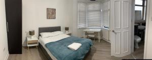 a bedroom with a bed and a desk and a window at Beautiful All room En-suite 4 bedrooms house , Free parking, WiFi, Corporate, Contractors, Family relocation, CONTACT US FOR LONG TERM RATE in Ilford