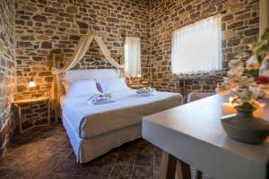 a bedroom with a bed in a brick wall at Palaeopoli Villas in Avlemonas