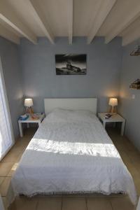 a bedroom with a large white bed with two tables at Appartement villa Oceanides 500m de la plage N 8 in Soulac-sur-Mer