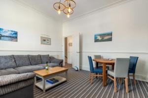 a living room with a couch and a table at Top Sail - Beautiful Apartment, Minutes Walk to Beach and Town Centre in Tenby